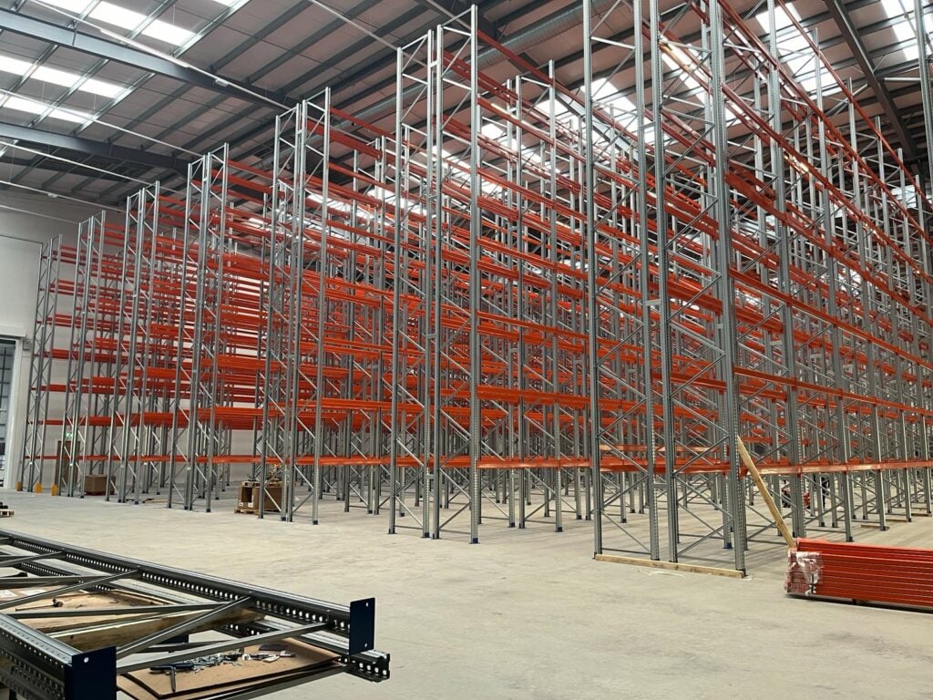 Newly installed high-bay pallet racking system in a large warehouse facility.